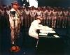MacArthur signing Japanese surrender aboard USS Missouri.