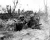 Marine Pfc. Douglas Lightheart (right) cradles his M1919 Browning machine gun in his lap, while he and his buddy Pfc. Gerald Thursby Sr. take time out for a cigarette.