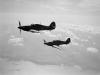 Two Hurricane Mk IIC night fighters of No. 247 Squadron RAF based at Predannack, Cornwall, in flight over the sea.