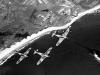 Canadian Hurricane fighters in flight over shore lines.