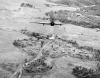 A Royal Air Force Hawker Hurricane IIC of No. 42 Squadron RAF based at Kangla, Burma, piloted by Flying Officer "Chowringhee" Campbell, diving to attack a bridge near a small Burmese settlement on the Tiddim Road. The bombs of the previous aircraft can be