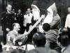 Fuhrer receives a present from two Santas while attending a Christmas party given by the Chief of the Chancellery.