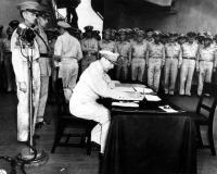 MacArthur signing Japanese surrender aboard USS Missouri.
