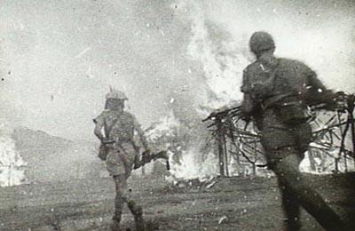 Australians destroying the village of Mindello to prevent its use as a base by the Japanese.