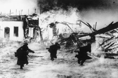 German soldiers move through a burning Norwegian village during the German invasion.