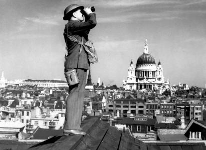 An aircraft spotter on the roof of a building in London, with St. Paul's Cathedral in the background.