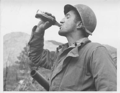 Soldier drinking Coca-Cola in Italy war theatre.