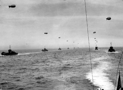 Convoy of landing craft on the way to Normandy. Each with its barrage balloon connected by a cable.