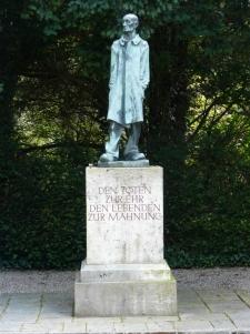 This statue by Fritz Koelle stands outside of the Dachau crematory: 'To honor the dead, to admonish the living'.