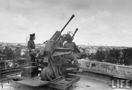 American WACs (Women's Army Corps) examining the anti-aircraft guns atop German flak tower in the Tiergarten section of city following the capture of Berlin by Allied troops.