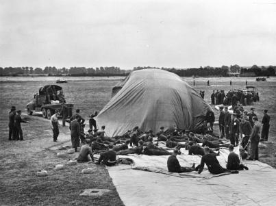 Air force personnel inflating barrage balloon.