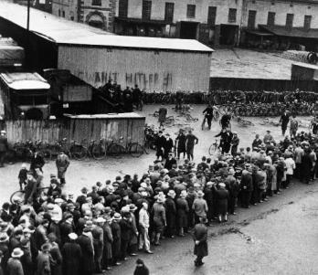 Queue of unemployeds in front of Employment Center. In the wall we can read: 'Vote in Hitler!'