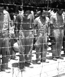 Japanese POWs at Guam, with bowed heads after hearing Emperor Hirohito make announcement of Japan's unconditional surrender.