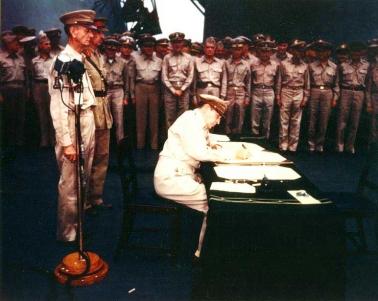 MacArthur signing Japanese surrender aboard USS Missouri.