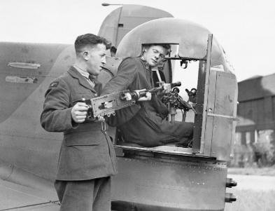 Armourers installing a Browning machine guns into the rear turret an Armstrong Whitley Mk V of 58th Squadron of RAF.