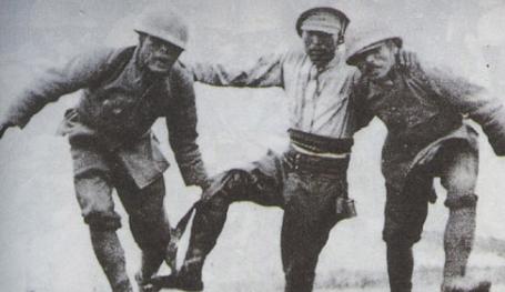 Two Japanese soldiers helping a wounded comrade off the battlefield near Suzhou Creek.