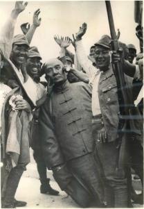 Japanese soldiers pose next to a bronze statue of Sun Yat-sen after capturing Shanghai.
