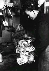 Inflation in Germany. Money loses almost all its value. In the photo, a German woman prepares to light her stove with a bundle of paper currency